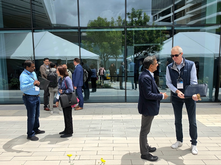 Attendees of the SAFE™ Forum 2026 enjoy a casual outdoor lunch under canopy tents, engaging in friendly conversation around a white-cloth