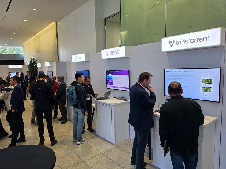 Attendees explore interactive digital displays at the SAFE™ Forum 2026, engaging in discussions along a well-lit hallway with large windows.