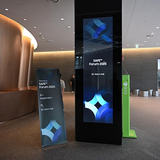 A digital display and standing banner at the entrance of the SAFE™ Forum 2025 direct attendees to the B2 Vision Hall for registration.