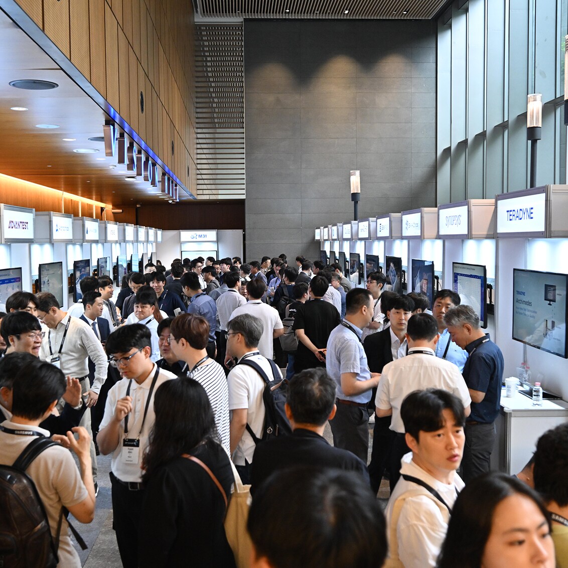 A crowded exhibition hall at SAFE™ Forum 2025 features numerous booths from tech companies, with attendees actively engaging and networking.
