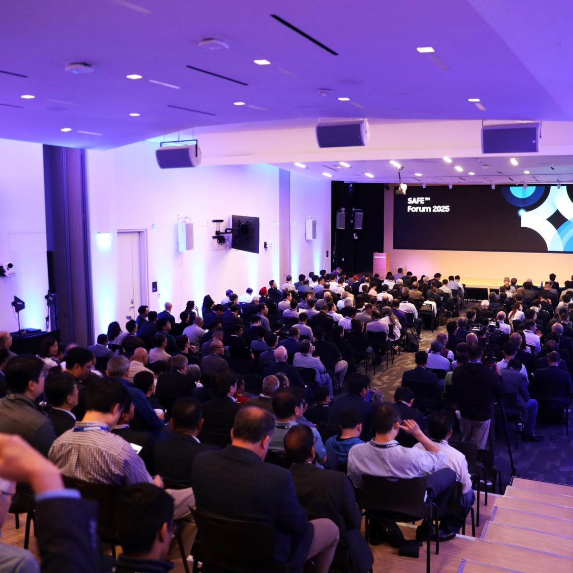 The SAFE™ Forum 2025 hosts a full-capacity session in a modern, well-lit conference hall, with attendees focused on a main stage presentation.