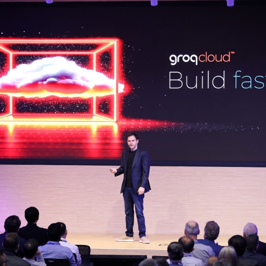 A keynote speaker presents on stage at the SAFE™ Forum 2025, standing before a large screen displaying 'groqCloud™ Build fast' with a digital cloud graphic.