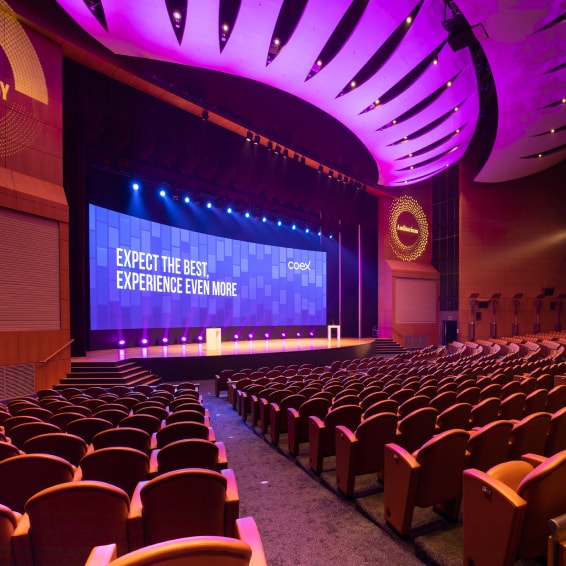 Interior view of the COEX Auditorium with 'Expect the best, Experience even more' displayed on a monitor