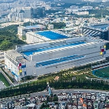 A bird`s-eye view of a semiconductor facility, displaying its expansive industrial buildings and proximity to residential and commercial areas.