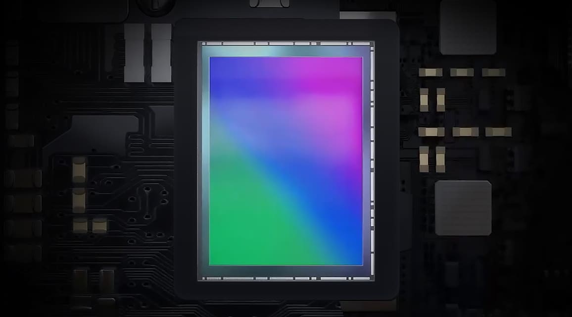 Image of a colorful image sensor against a dark circuit board background.