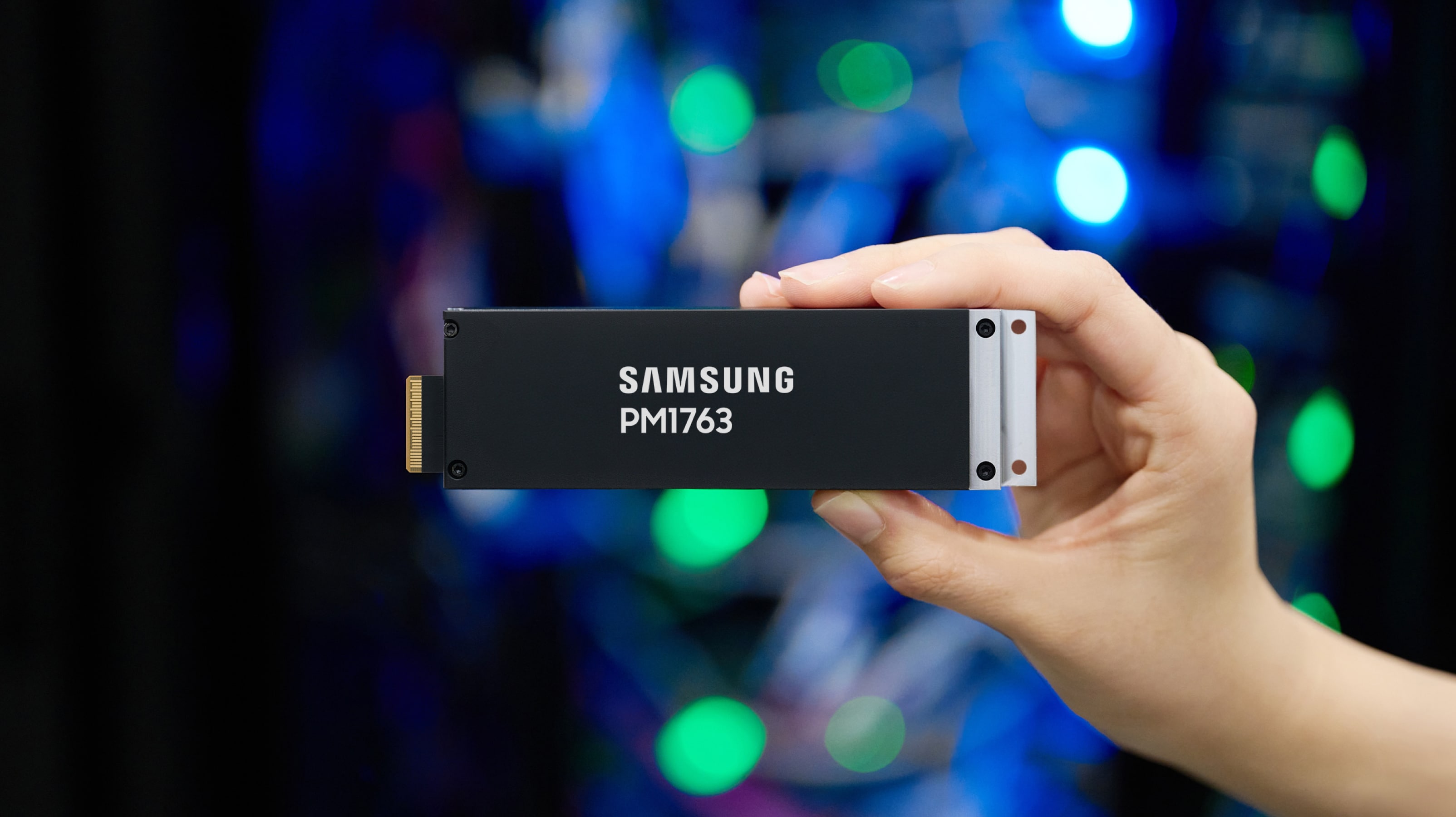 Samsung PM1763 enterprise SSD held in front of data center equipment