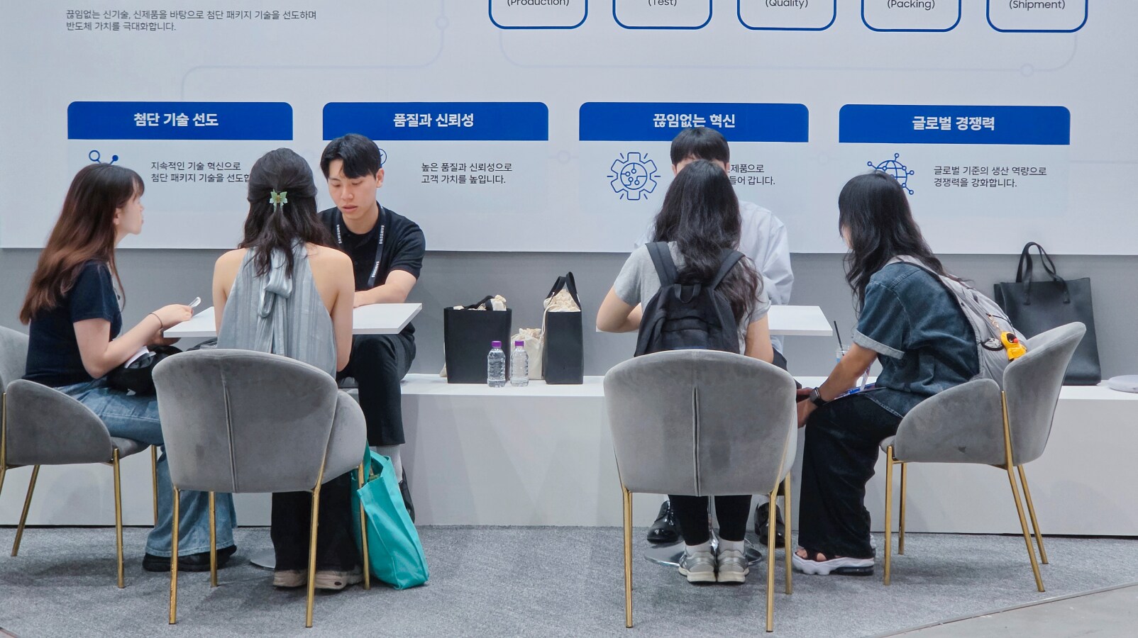 TSP 총괄 부스에서 AI 반도체 패키징 기술과 생산·검사·품질 관리·포장·출하 공정, 관련 직무 및 채용 정보를 상담하는 방문객들