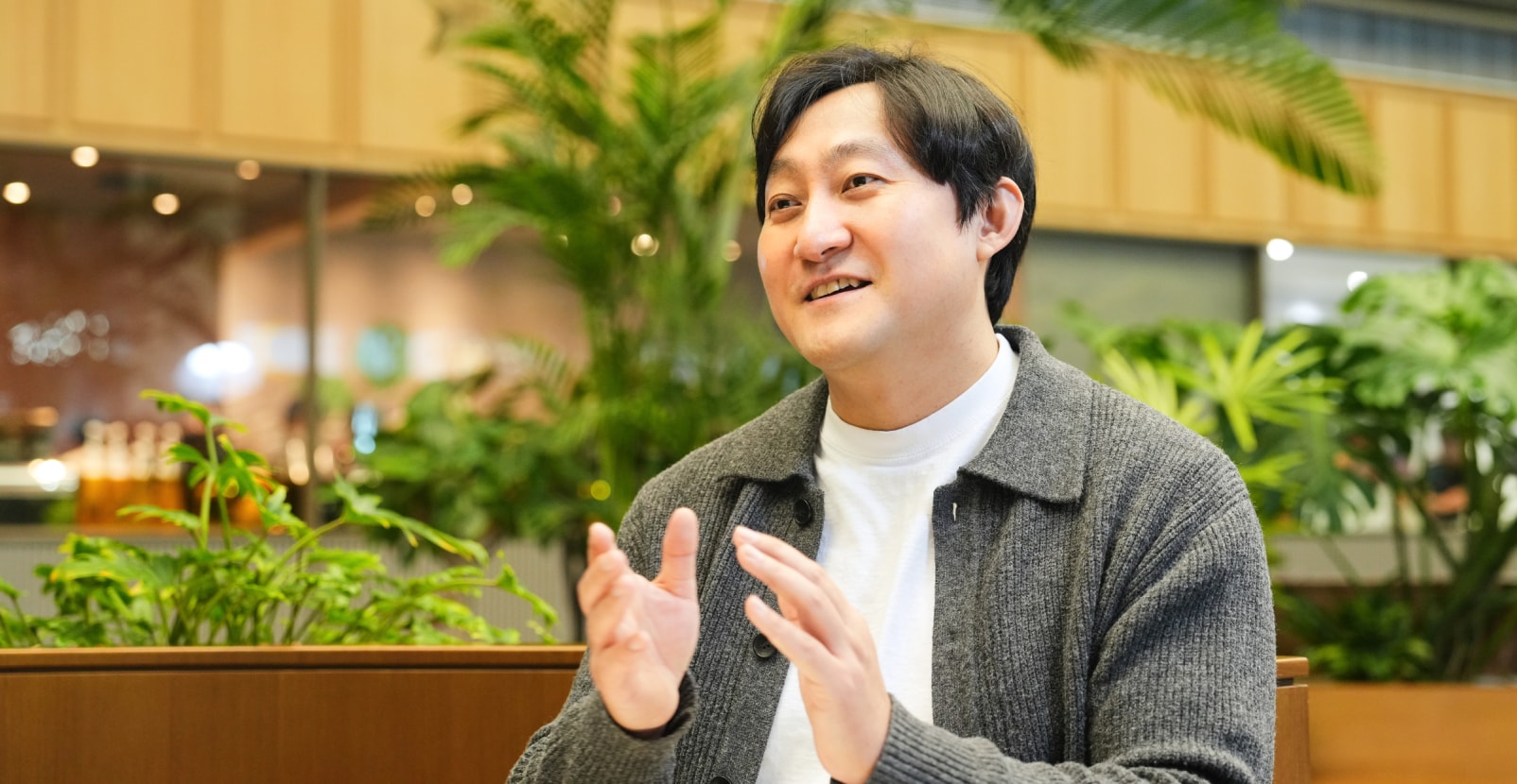 Security&Power제품개발팀의 김지철 님이 자연스러운 손짓과 미소로 대화를 나누는 모습으로, 따뜻한 톤의 실내 공간 분위기를 담음