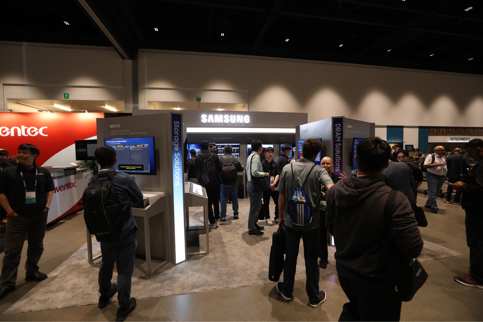 Visitors exploring the Samsung booth at 2024 OCP Global Summit, showcasing Storage and DRAM Solutions with interactive displays and product information panels.