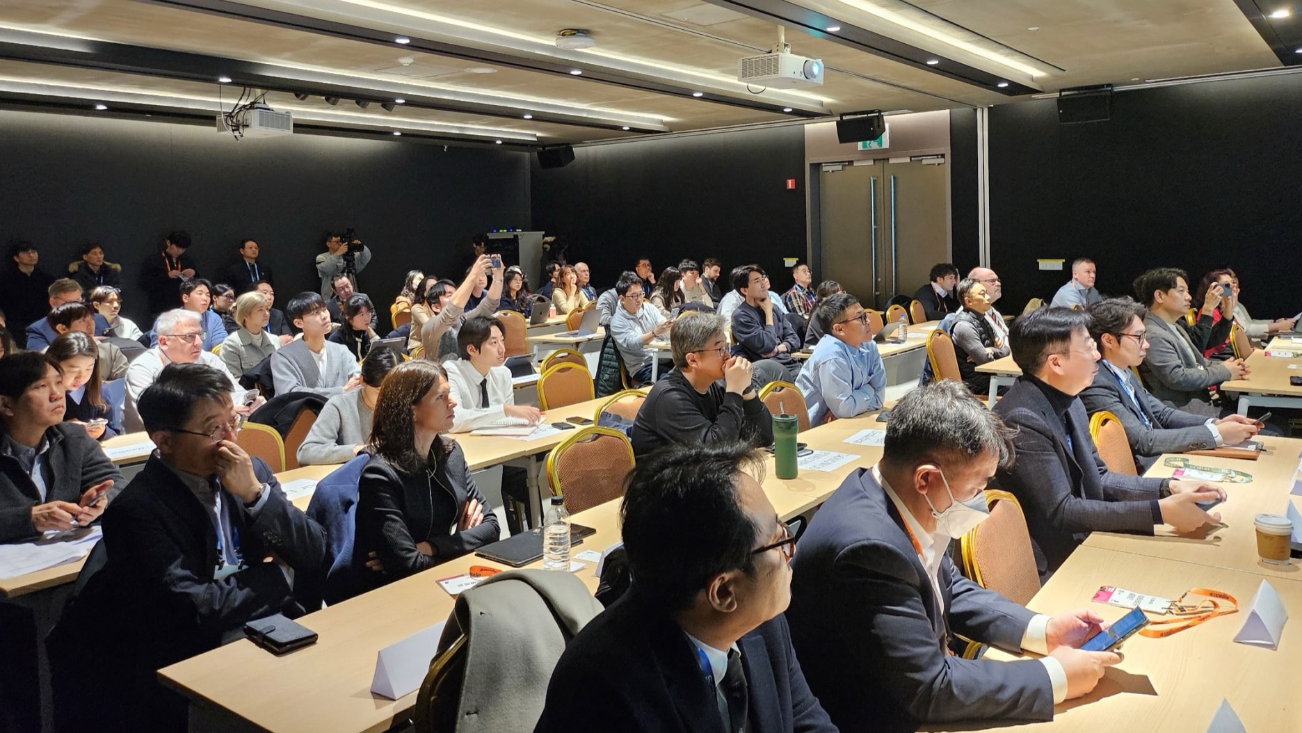 A packed conference room with attendees focused on the presentation.