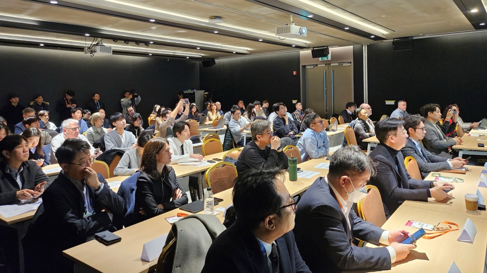 A packed conference room with attendees focused on the presentation.