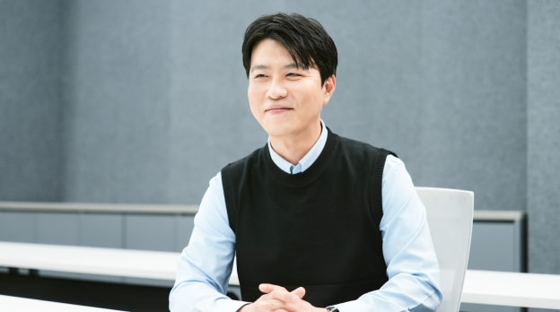 회의실에서 책상 앞에 앉아 있는 남성.