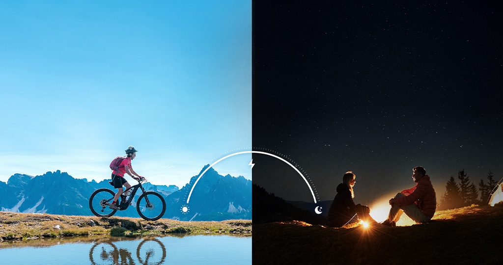 A split image showing a cyclist during the day and two people by a campfire at night, illustrating the smartphone’s long-lasting battery life from morning to night.