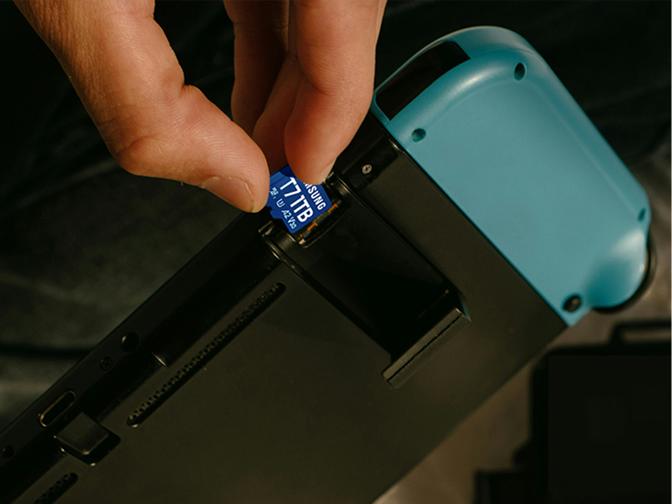 携帯型ゲーム機に T7 microSD カード T7 を差し込む手