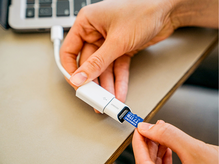 T7 microSD カードをノートパソコンの接続アダプタに差し込む手