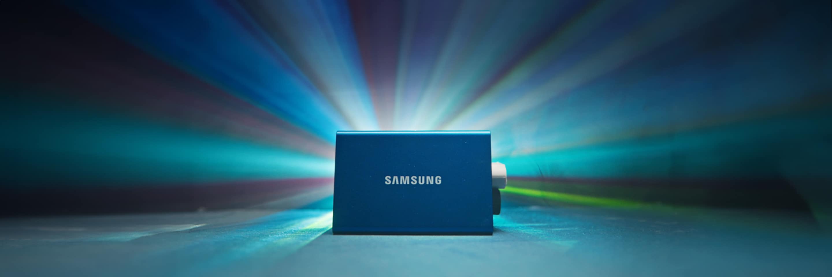 The Samsung T7 stands against a backdrop of colorful lights. 