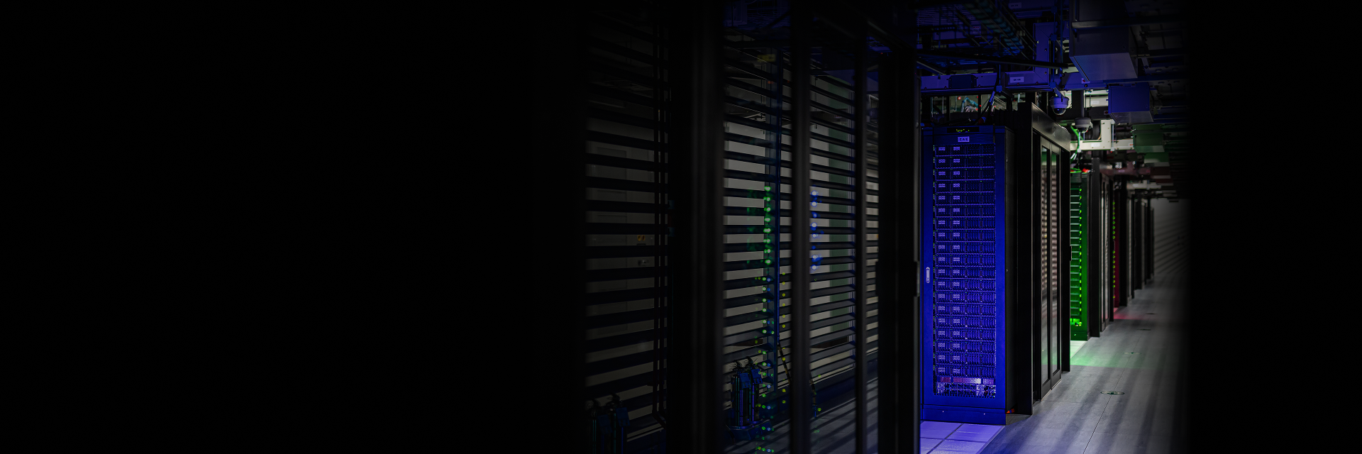 Interior view of a data center with multiple server racks and active computing hardware.