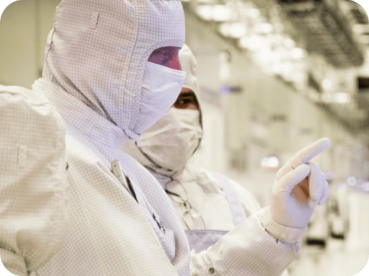 A person in a cleanroom suit inspecting something