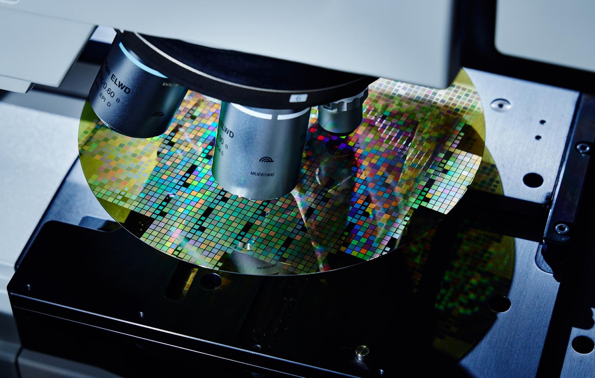 半導体製造工程におけるウェーハ検査装置の光学顕微鏡レンズがシリコンウェーハのパターンを検査しているクローズアップ.