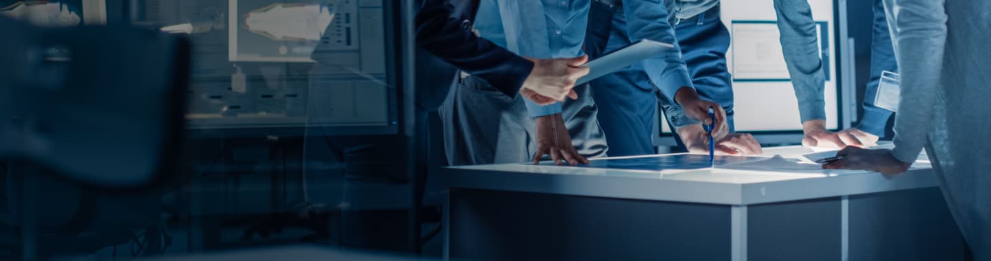 Close-up of hands on a lit table as business professionals engage in discussion