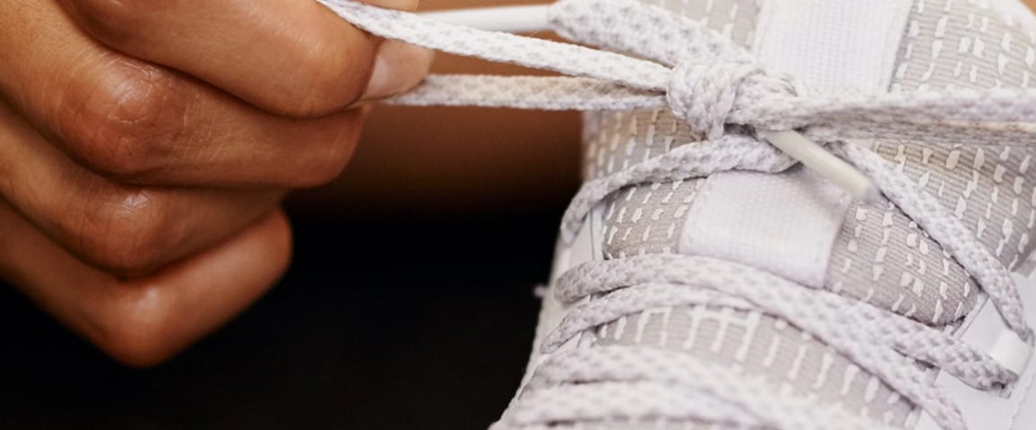 A picture of tying a shoelace.