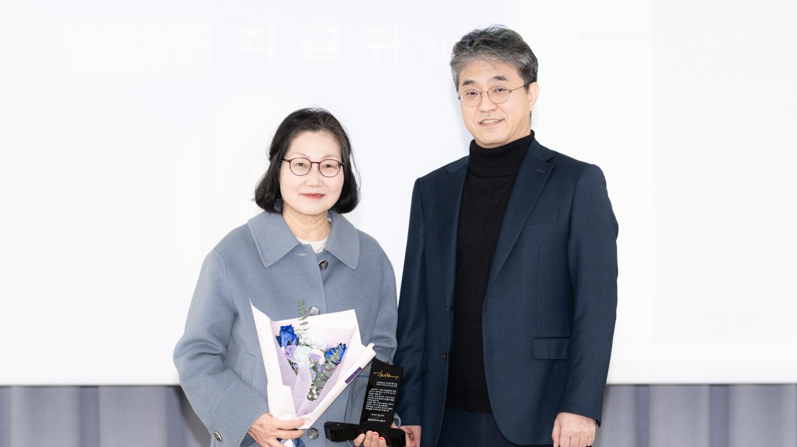 감사패와 꽃다발을 수여받은 병점 2동 최금휘 위원의 모습