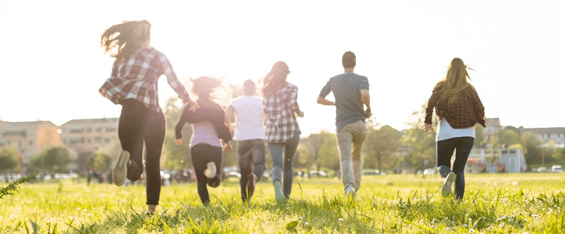 A picture of young people filled with hope, running on grass.