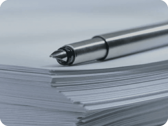 An image of a silver fountain pen on a stack of paper.