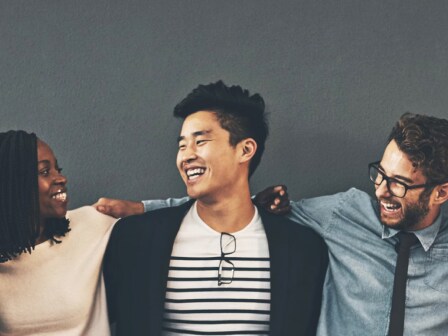 Many people with diversity smiling and putting their arms around each other’s shoulders