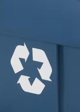 There is a white recycling symbol on a blue wall.