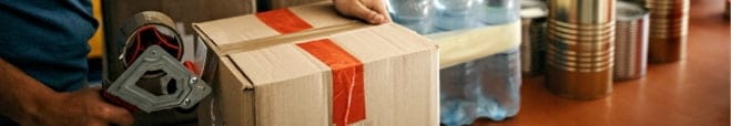 A person is taping up the box.