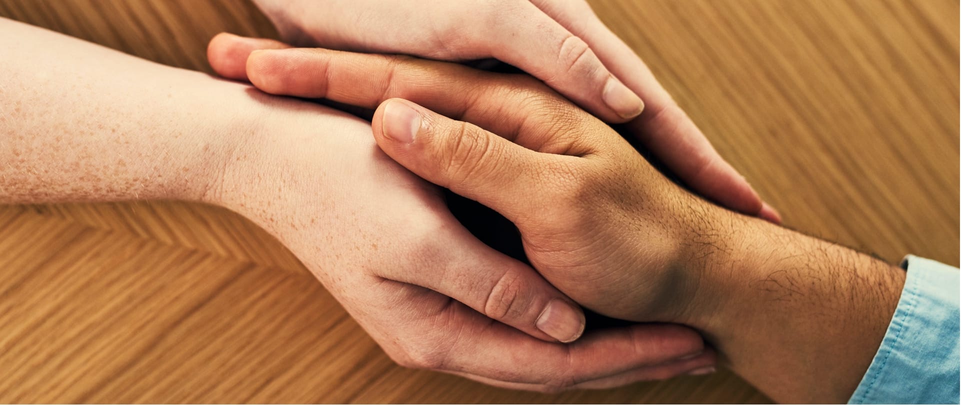Top view of hands holding another person's right hand.