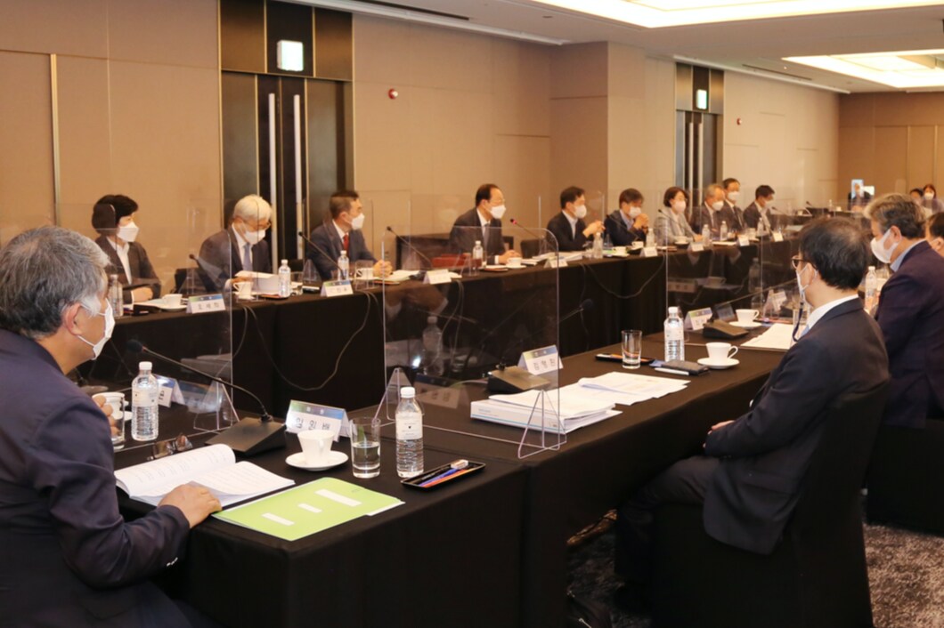 人々が会場で丸く座り会議を行っています。