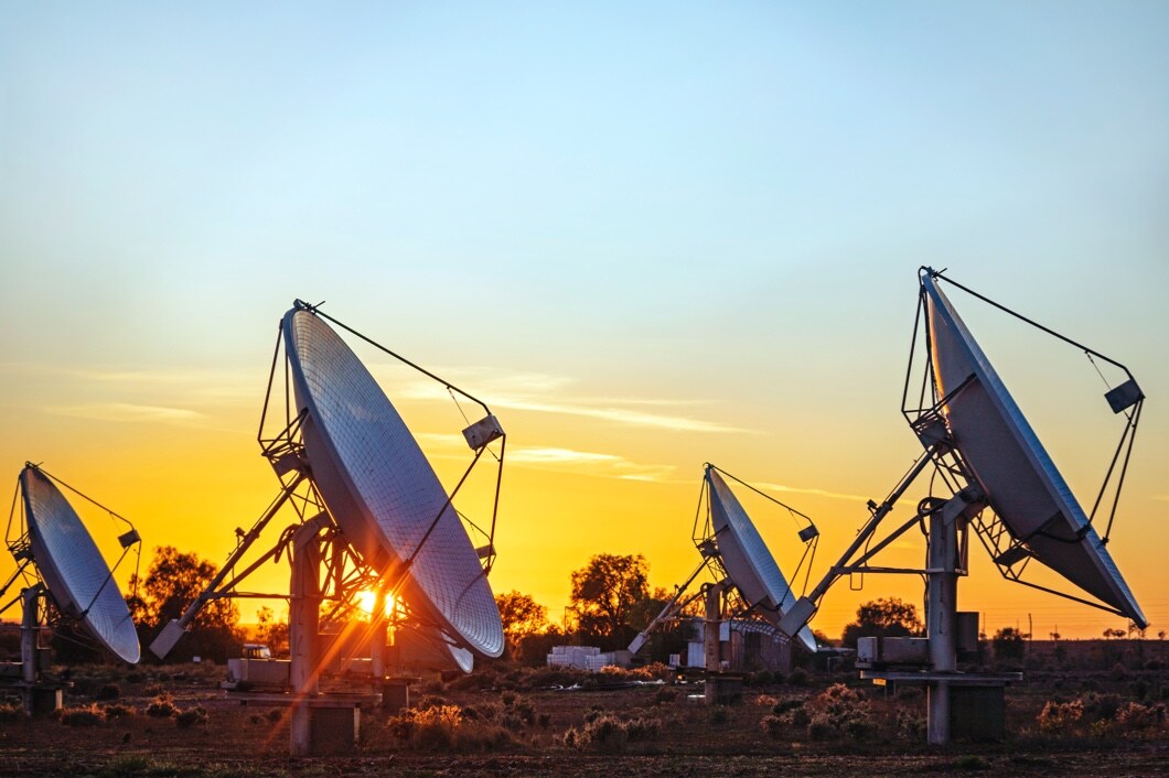 Four satellites are set up outside with their antennas facing up toward the sky.