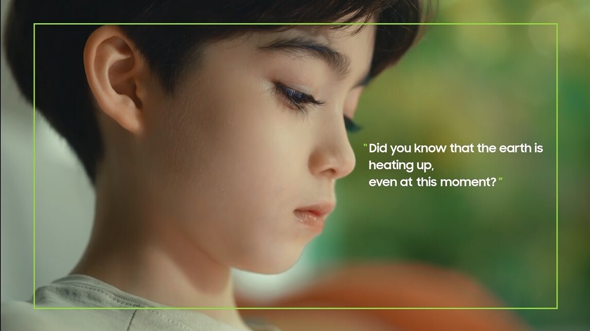 A side view of a boy looking down as if lost in thought and the phrase "Did you know that the earth is heating up, even at this moment?"