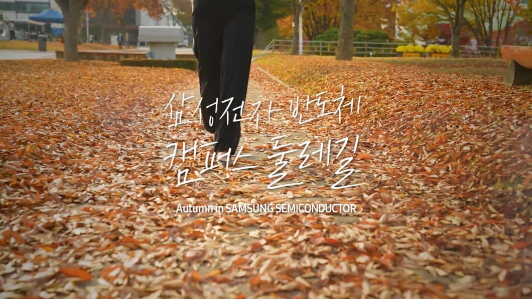 낙엽이 떨어진 산책로를 걸어가는 여자의 다리가 보입니다.